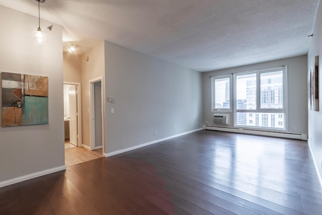 spare room featuring a baseboard heating unit, a textured ceiling, and hardwood / wood-style floors