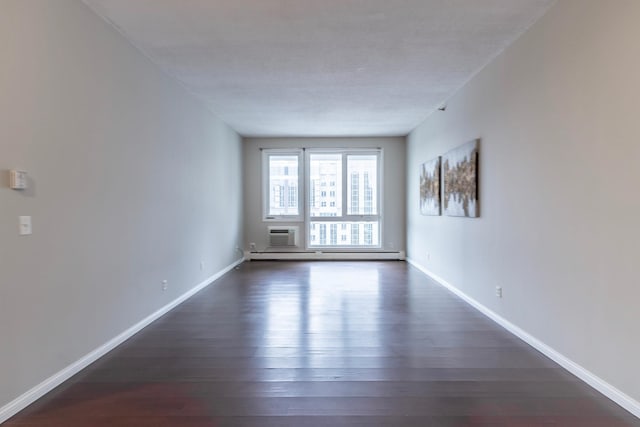 unfurnished room featuring a textured ceiling, dark hardwood / wood-style flooring, an AC wall unit, and a baseboard radiator