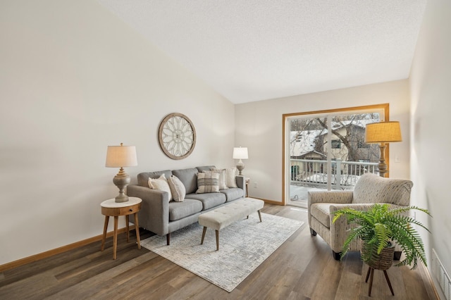 living room with a textured ceiling and dark hardwood / wood-style floors