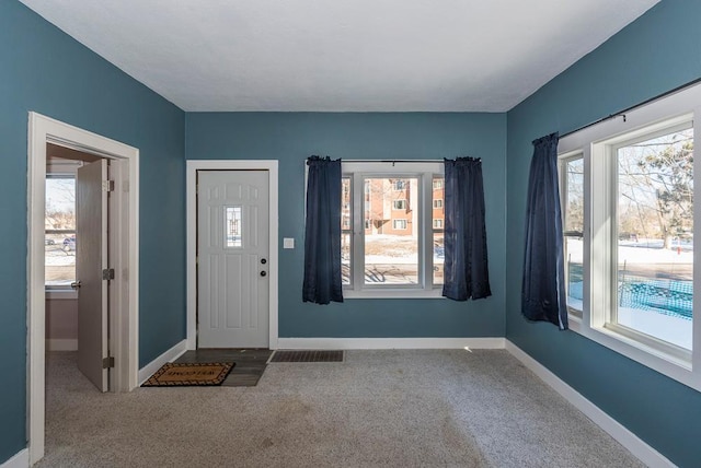 foyer featuring carpet, visible vents, and baseboards