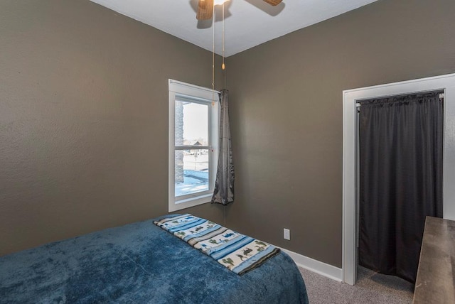 carpeted bedroom with ceiling fan and baseboards