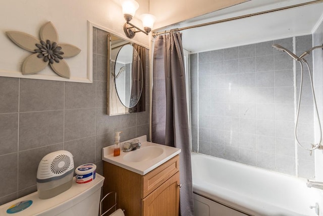 bathroom featuring toilet, vanity, shower / bath combination with curtain, and tile walls