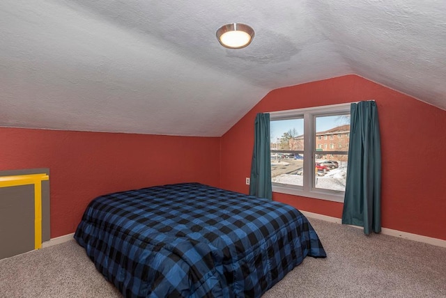 bedroom with a textured ceiling, carpet, lofted ceiling, and baseboards