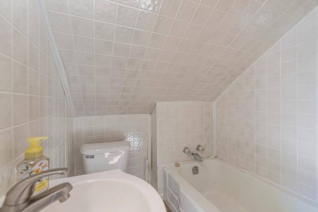 full bath with tile walls, lofted ceiling, toilet, a bathing tub, and a sink