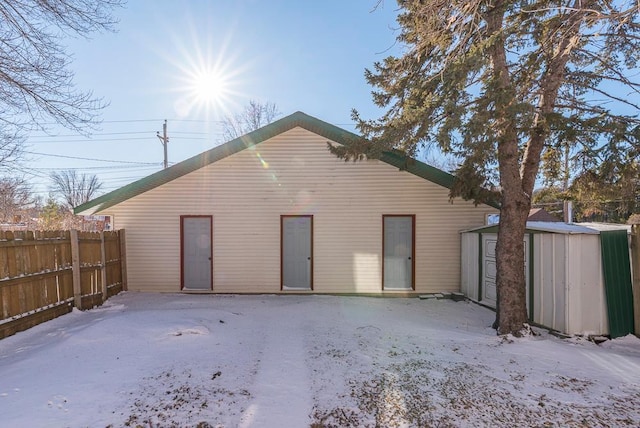 garage with fence and a shed