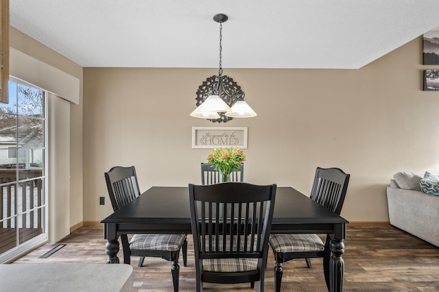 dining space featuring dark hardwood / wood-style floors and a chandelier