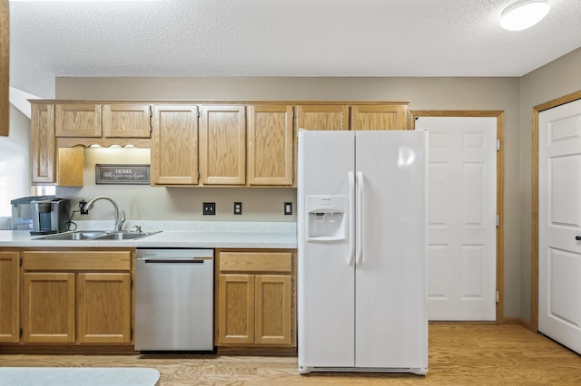 kitchen featuring sink, light wood-type flooring, white fridge with ice dispenser, stainless steel dishwasher, and a textured ceiling