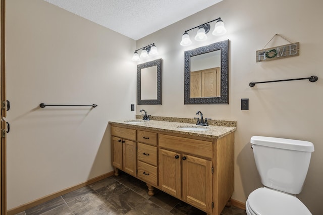 bathroom with vanity, a textured ceiling, and toilet