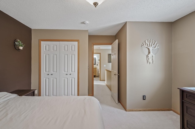 bedroom with light carpet, a closet, and a textured ceiling