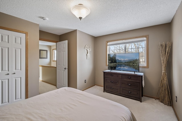 carpeted bedroom with a closet and a textured ceiling