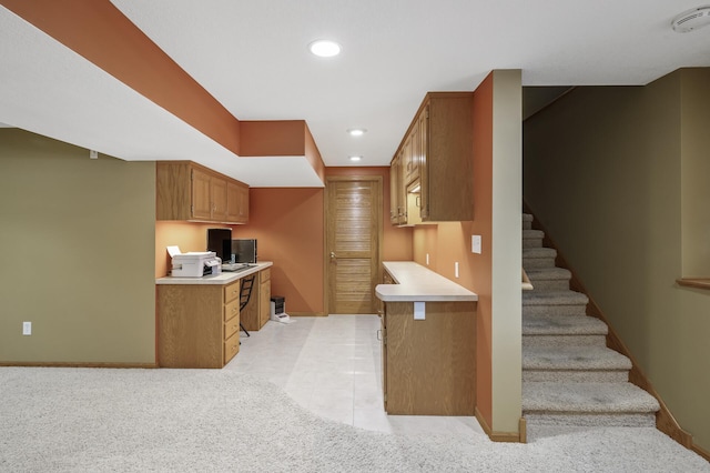 kitchen featuring light tile patterned floors and built in desk