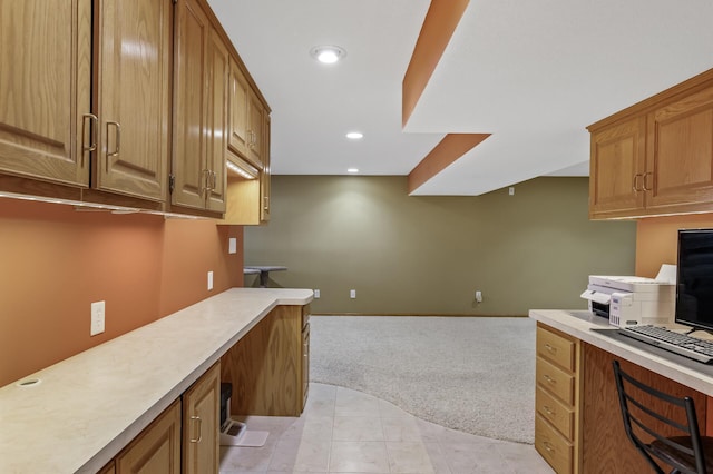 kitchen with built in desk and light carpet