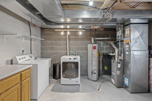 clothes washing area featuring separate washer and dryer, heating unit, and water heater