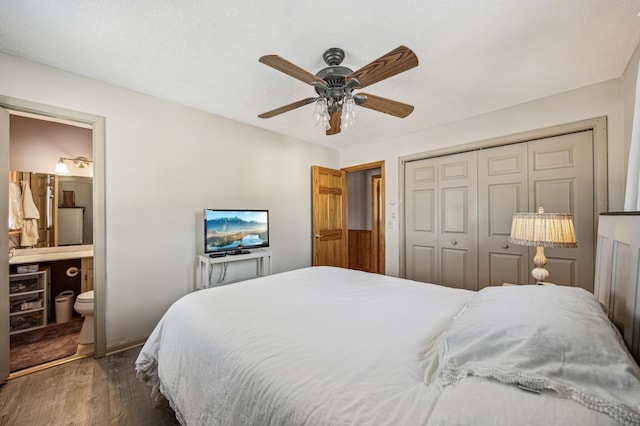 bedroom with ceiling fan, dark hardwood / wood-style floors, connected bathroom, a textured ceiling, and a closet