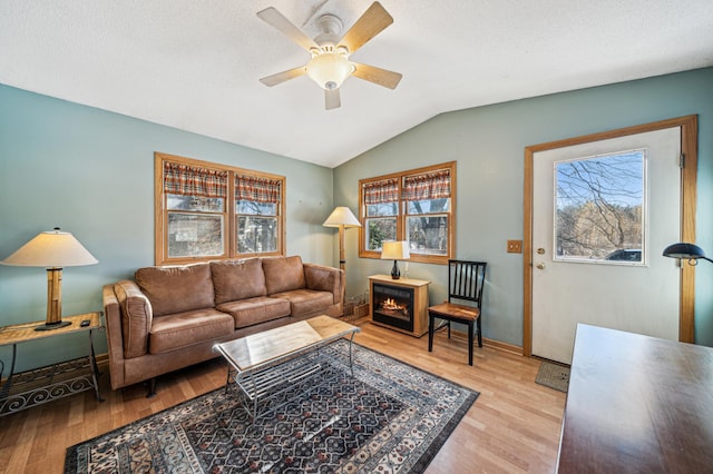 living room featuring vaulted ceiling, plenty of natural light, and light hardwood / wood-style floors