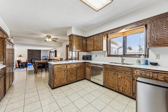 kitchen with dishwasher, sink, light tile patterned floors, ceiling fan, and kitchen peninsula