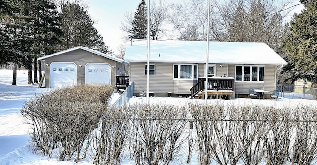 single story home with an outbuilding, fence, a wooden deck, and a garage