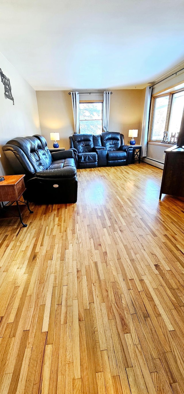 living room with a baseboard radiator and light wood-type flooring