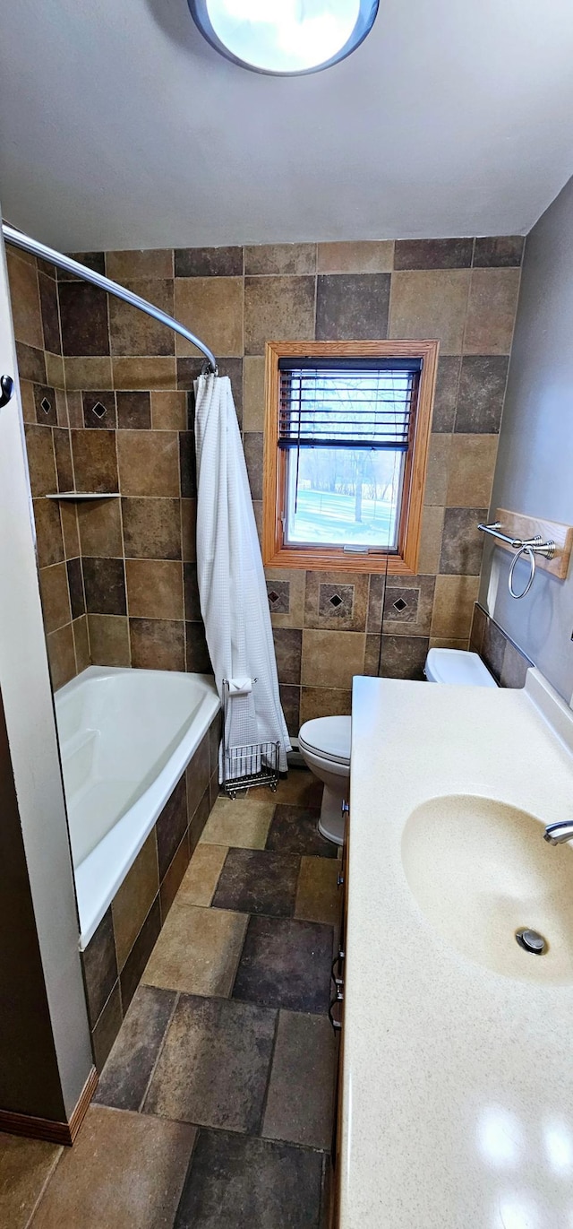 full bathroom featuring shower / tub combo with curtain, vanity, tile walls, and toilet