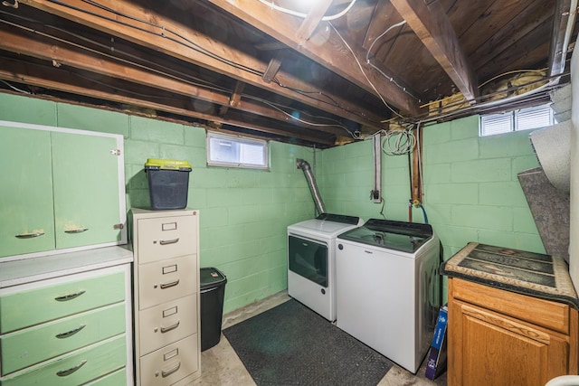 washroom with cabinet space, washer and clothes dryer, and a wealth of natural light