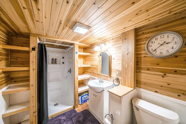 bathroom with wooden ceiling, toilet, wood walls, vanity, and a stall shower