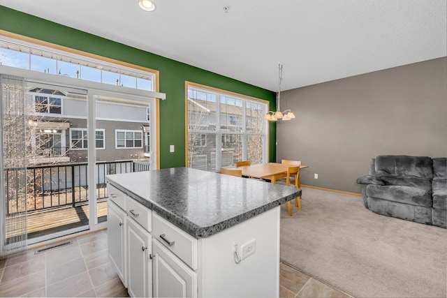 kitchen with a chandelier, light carpet, visible vents, white cabinets, and dark countertops