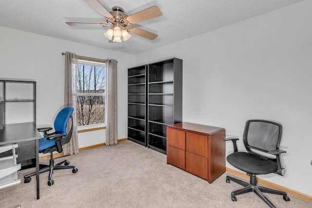 office featuring ceiling fan, baseboards, a textured ceiling, and light colored carpet