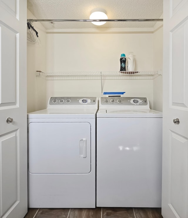 washroom with laundry area, washing machine and dryer, and a textured ceiling