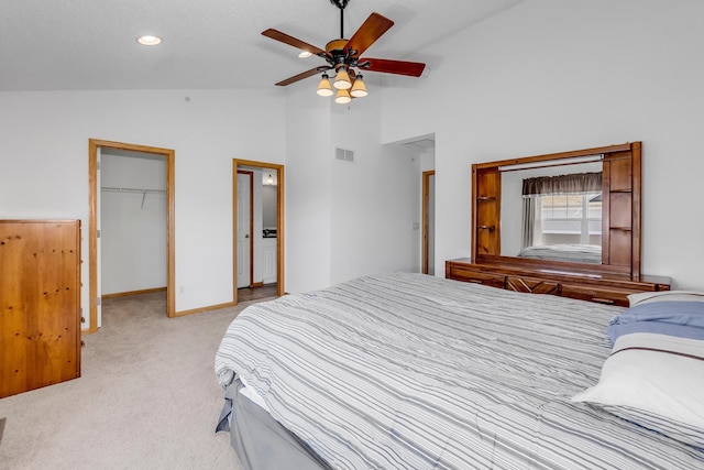 bedroom featuring light carpet, visible vents, baseboards, a closet, and a walk in closet