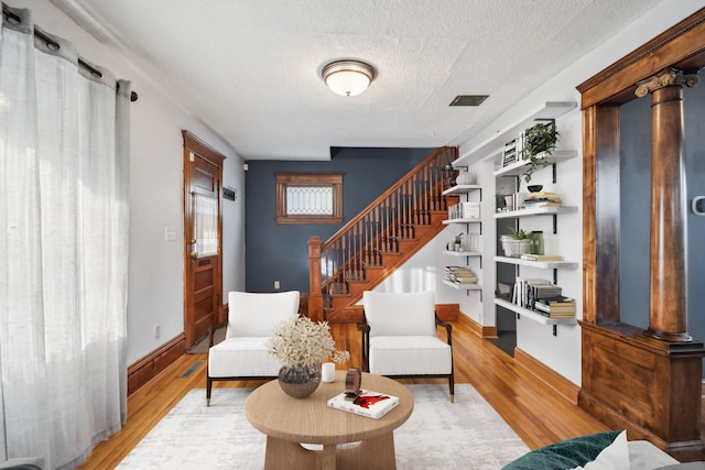 living room with light hardwood / wood-style floors and a textured ceiling