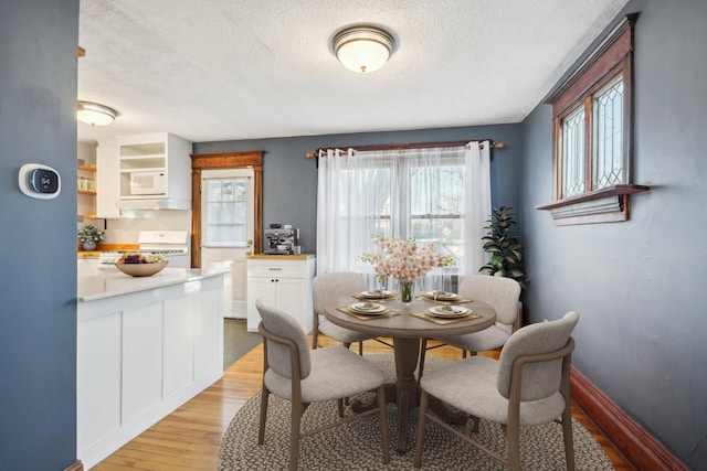 dining space featuring light hardwood / wood-style floors and a textured ceiling