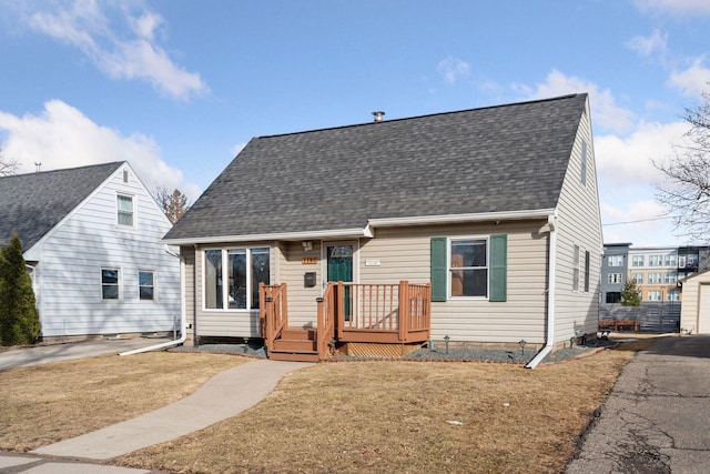 view of front of house featuring a front lawn and roof with shingles