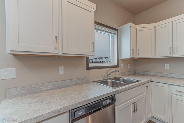 kitchen featuring stainless steel dishwasher, sink, and white cabinetry