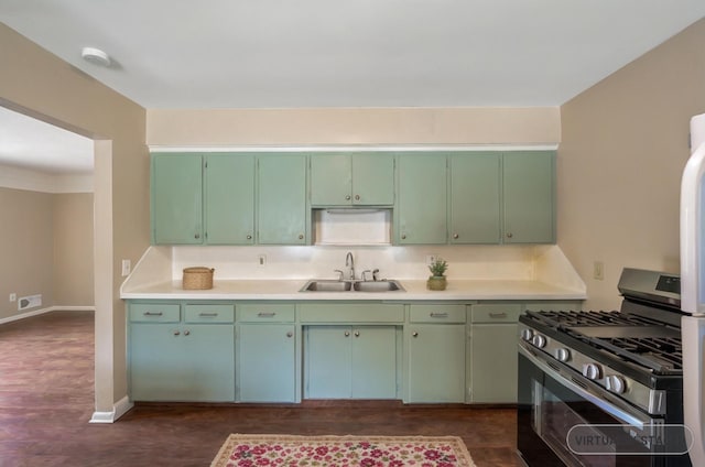 kitchen with sink, green cabinets, and gas stove