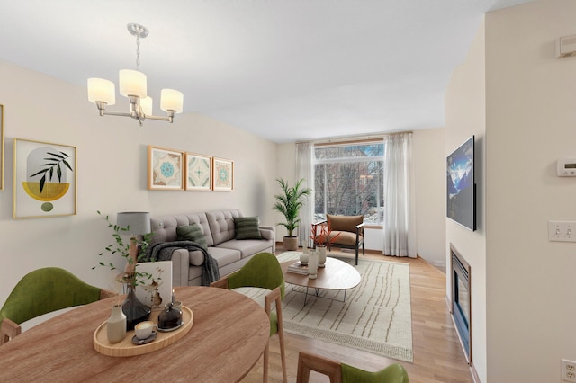 living room with light hardwood / wood-style flooring and a notable chandelier