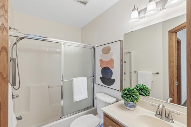 full bathroom with vanity, toilet, and combined bath / shower with glass door