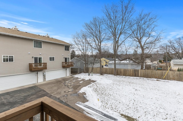 yard layered in snow featuring a garage