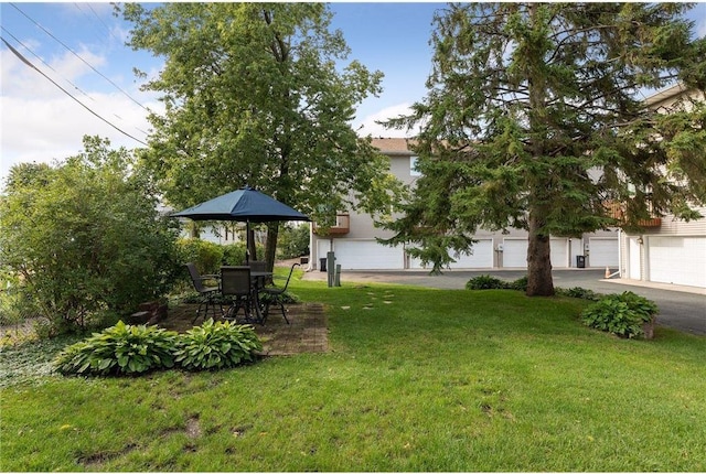 view of yard featuring a garage and a patio area