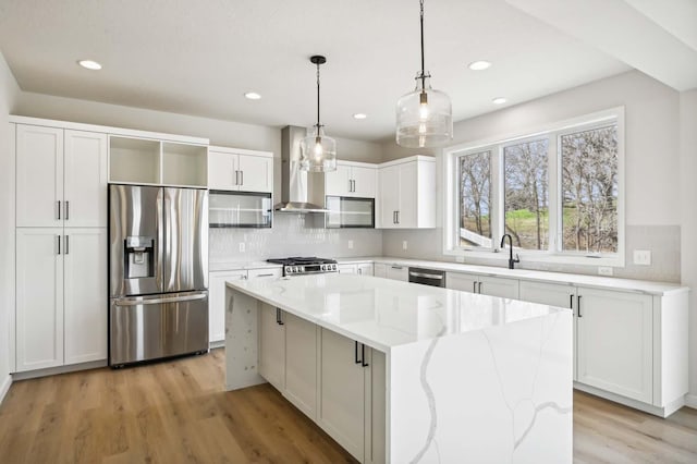 kitchen featuring decorative light fixtures, white cabinets, a center island, and stainless steel appliances