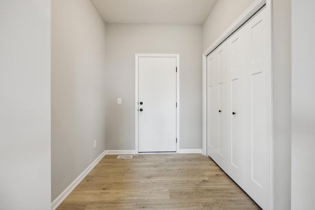 interior space featuring light wood-type flooring and baseboards