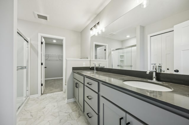 bathroom with a stall shower, marble finish floor, visible vents, and a sink