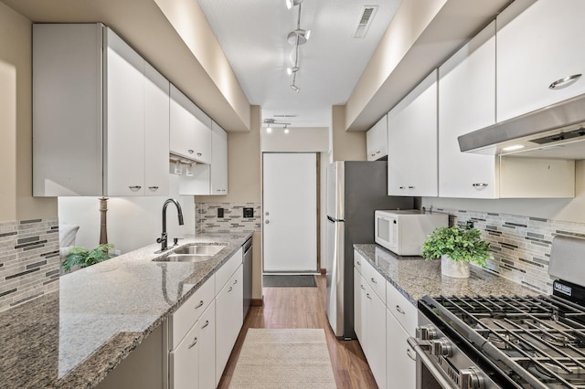 kitchen featuring sink, white cabinets, stainless steel appliances, and rail lighting