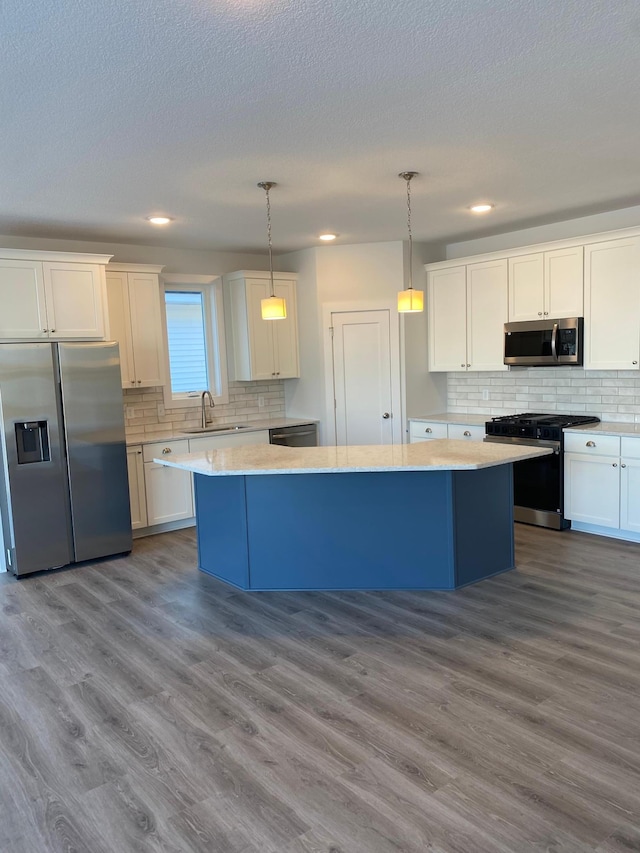 kitchen with white cabinets, stainless steel appliances, and pendant lighting