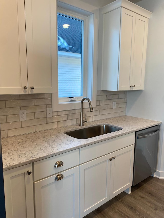 kitchen featuring light stone countertops, dishwasher, white cabinetry, sink, and dark hardwood / wood-style floors