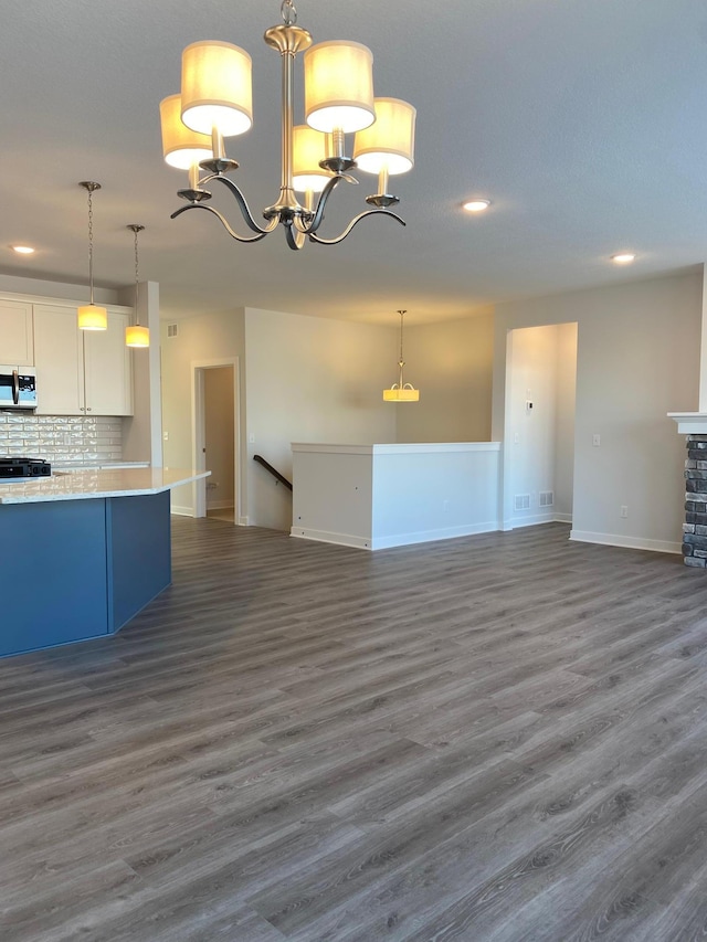 kitchen featuring dark wood-type flooring, white cabinetry, pendant lighting, and tasteful backsplash