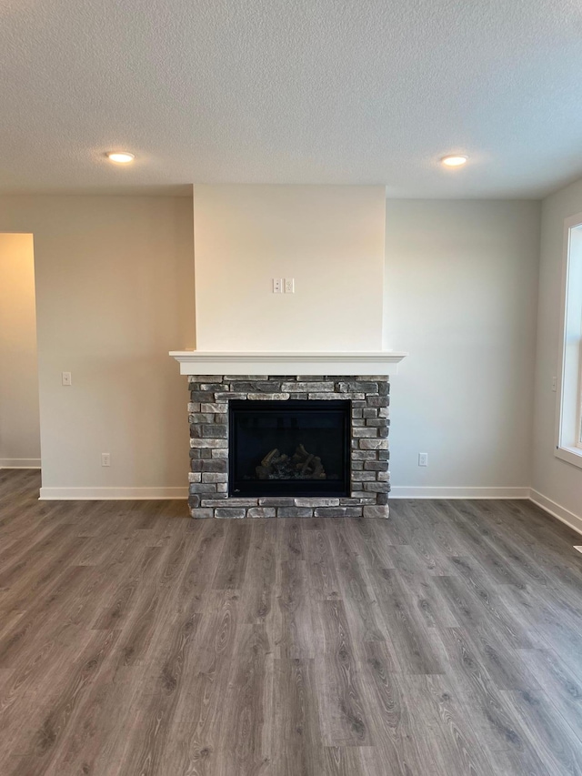 unfurnished living room featuring a textured ceiling, a fireplace, and hardwood / wood-style floors