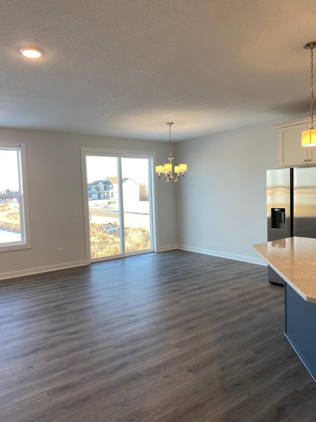 interior space featuring dark hardwood / wood-style flooring, an inviting chandelier, and a textured ceiling