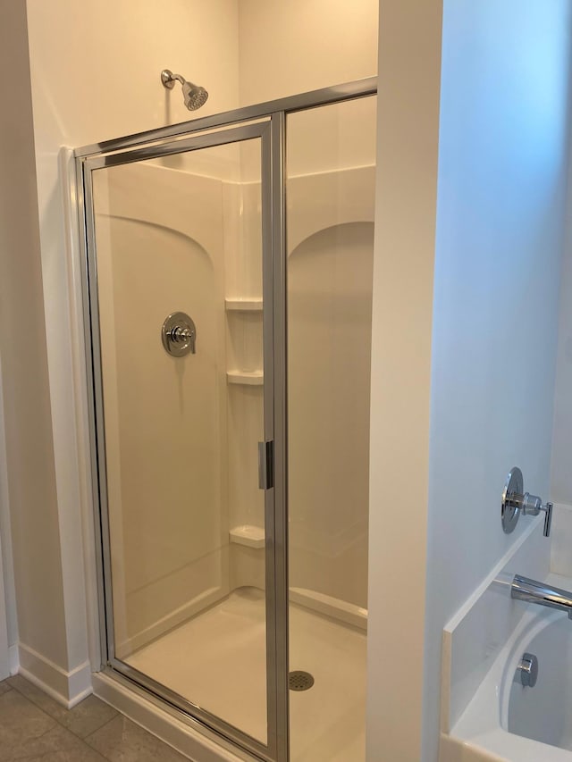 bathroom with tile patterned flooring and walk in shower