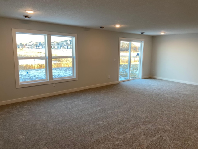 carpeted spare room with a textured ceiling