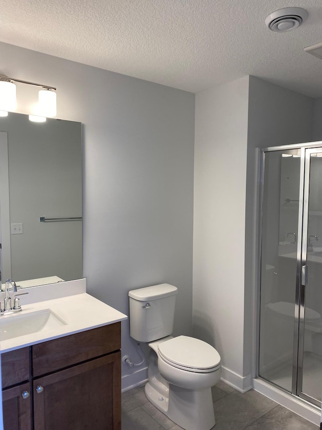 bathroom featuring walk in shower, vanity, toilet, and tile patterned flooring